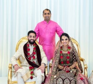 Arjun Pandey, a hindu priest taking photograph with a married couple